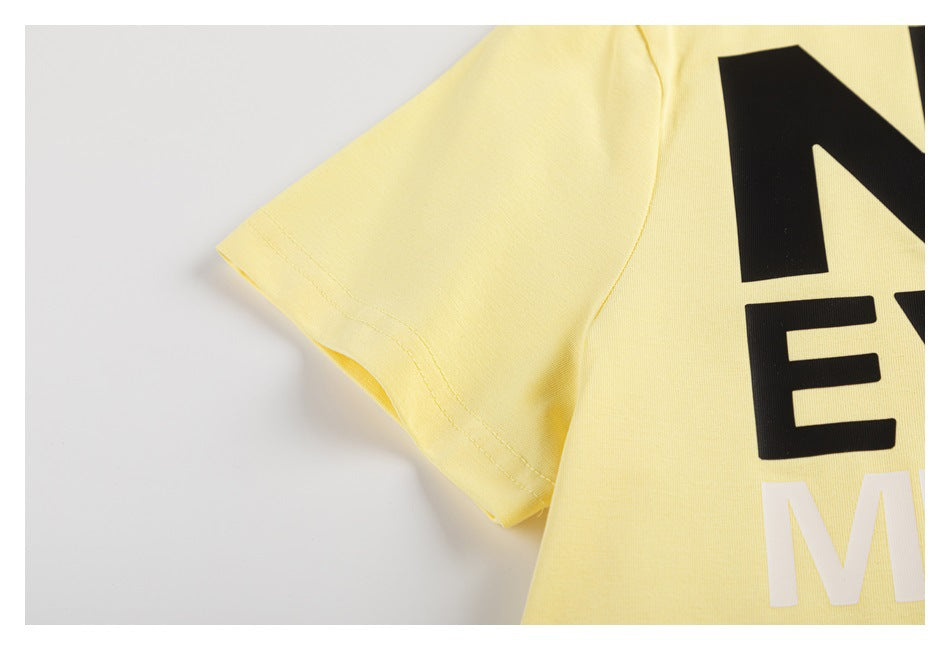 Close-up of a short sleeve and partial black and white lettering on the pale yellow T-shirt.