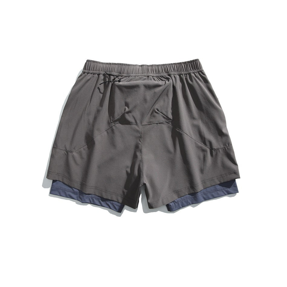Gray layered athletic shorts, back view, with an elastic waistband, center rear pocket and blue-gray inner shorts.