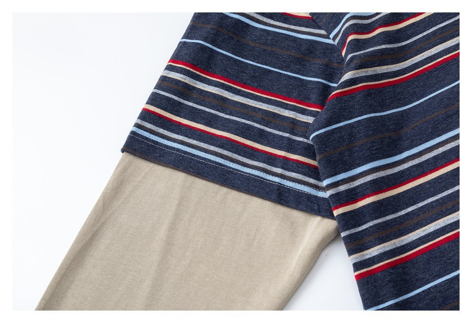 Close-up of a navy striped top with beige sleeve fabric and red, blue, cream, and gray stripes.