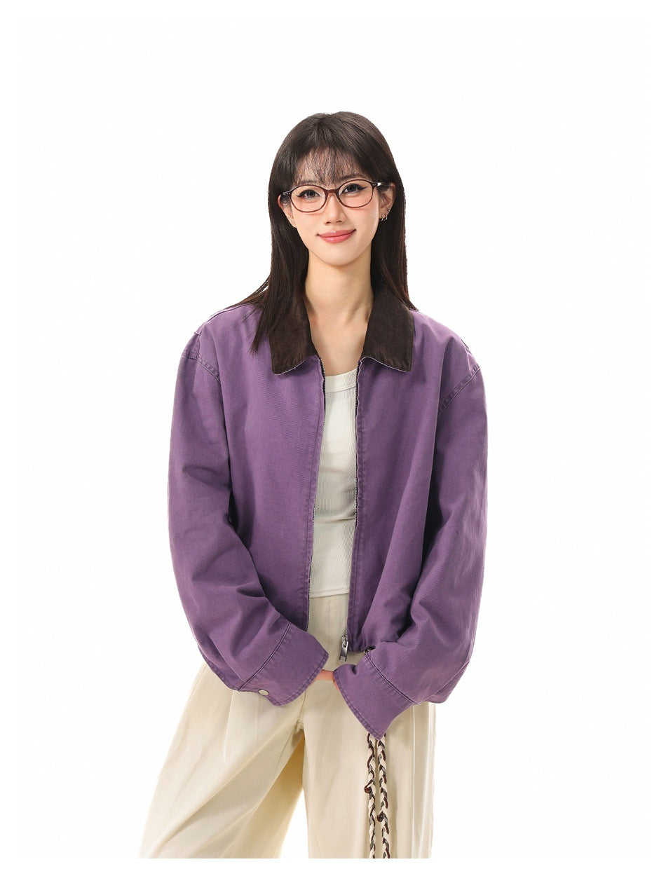 Front view of a model wearing an open purple jacket with a dark collar and cream trousers.