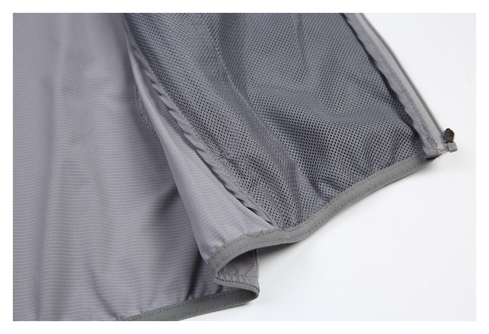 Close-up of dark mesh lining, gray binding, and zipper along an opening in gray striped fabric.