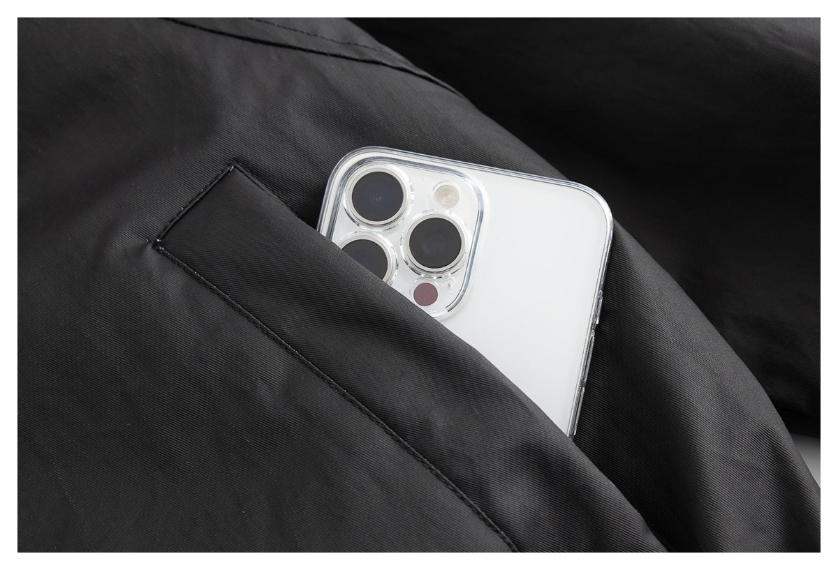 White smartphone tucked into a slanted pocket in black garment fabric.