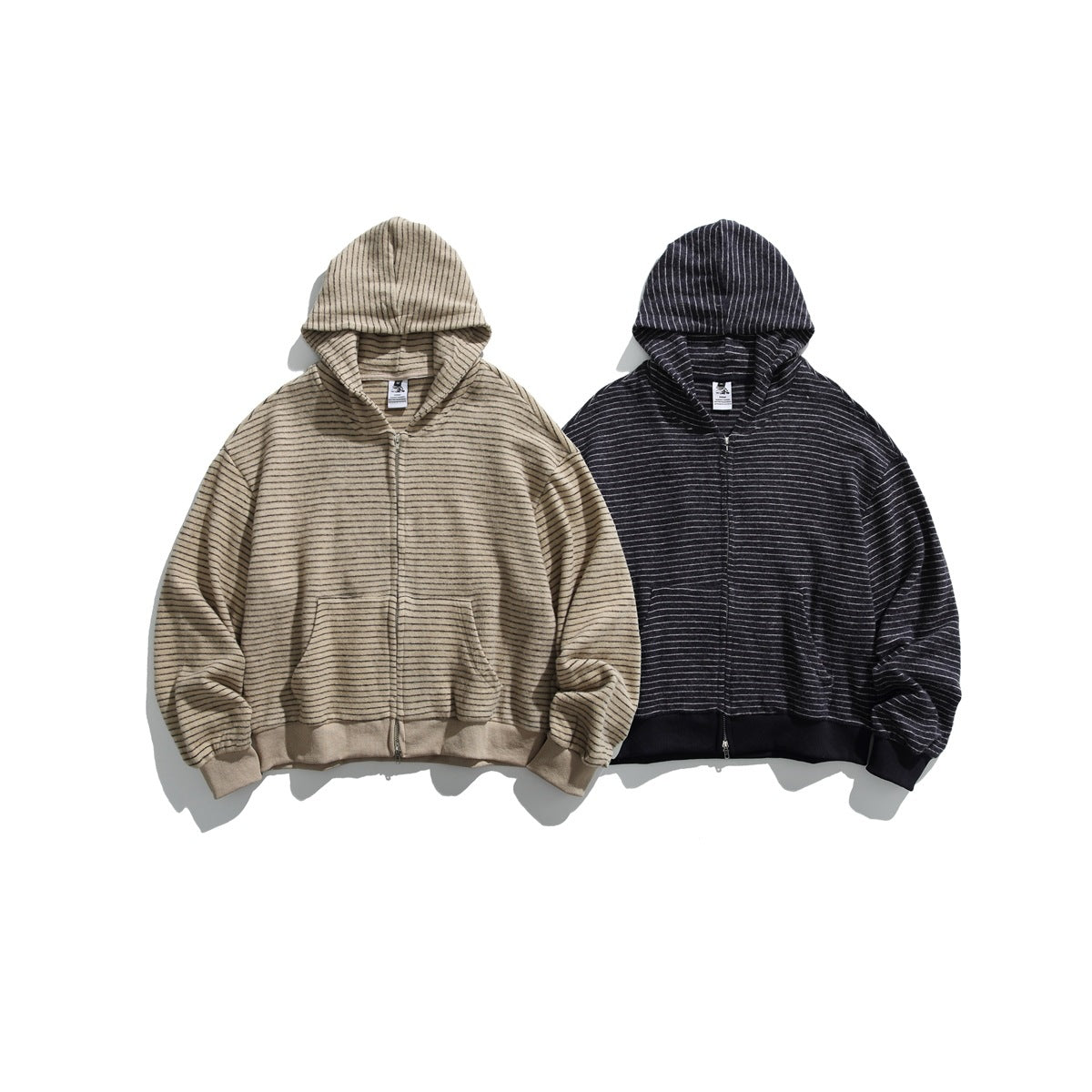 Two front views of zip-up hoodies with front pockets: beige with dark stripes and charcoal with light stripes.