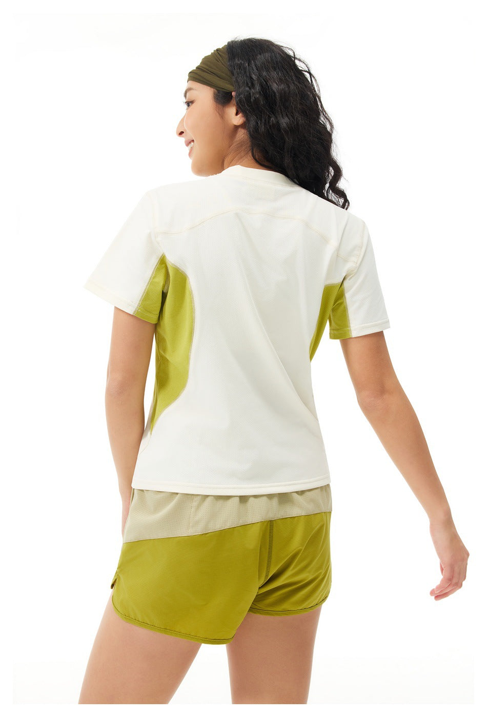 Back view of a model wearing a cream T-shirt with lime side panels and lime shorts.