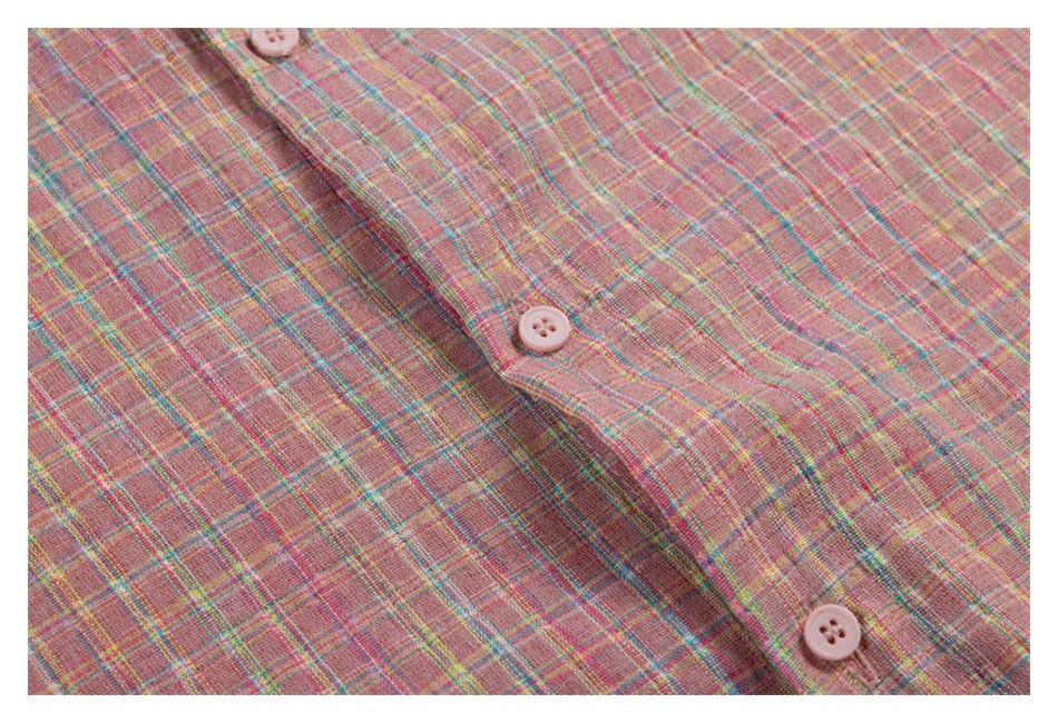 Close-up of the pink plaid shirt's front placket with pale pink buttons and intersecting colored lines.