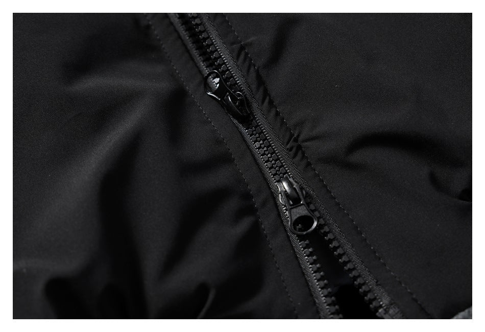 Close-up of a black jacket's front zipper with two zipper pulls.