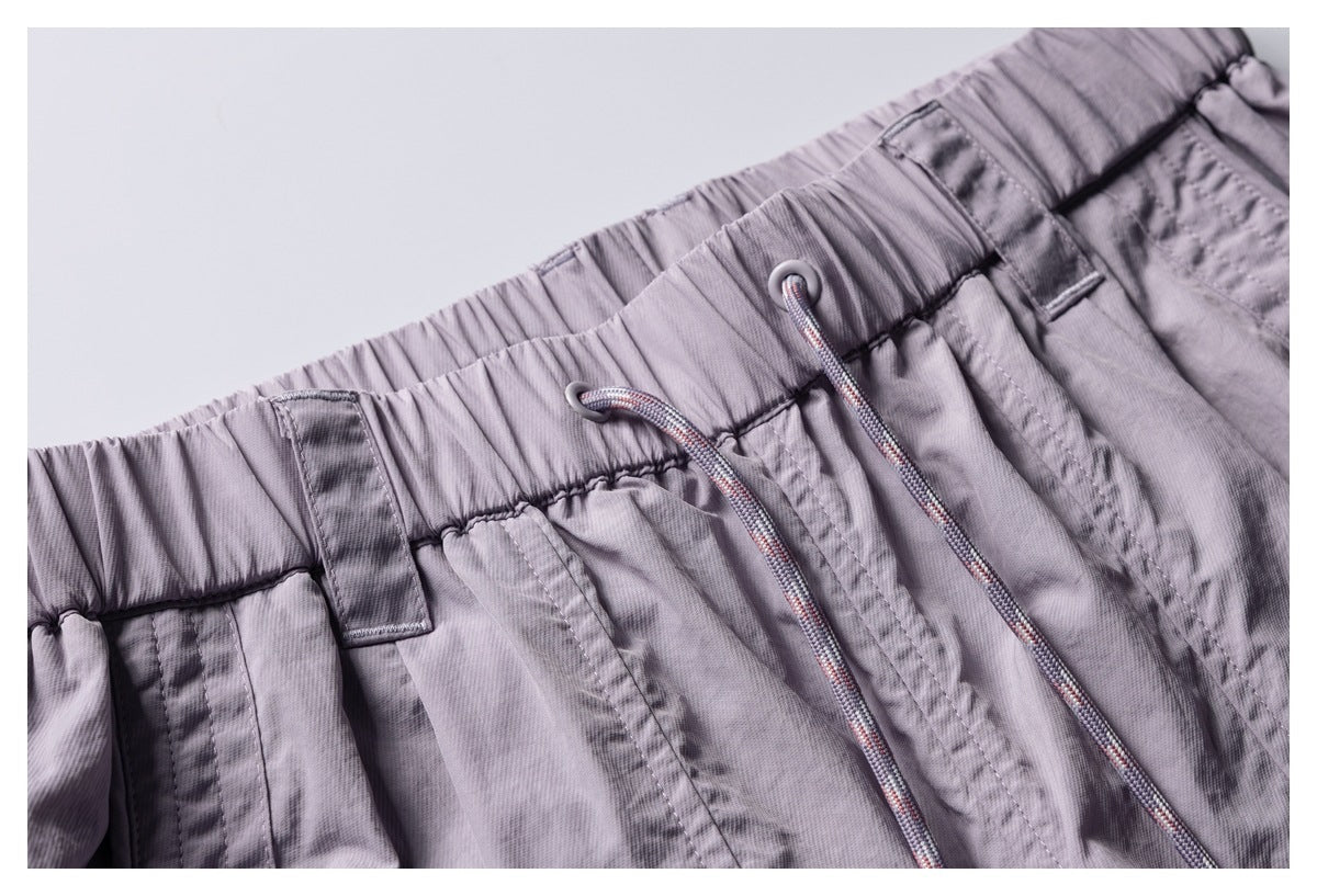 Close-up of the lavender pants' elastic waistband, belt loops, and multicolor drawcords.