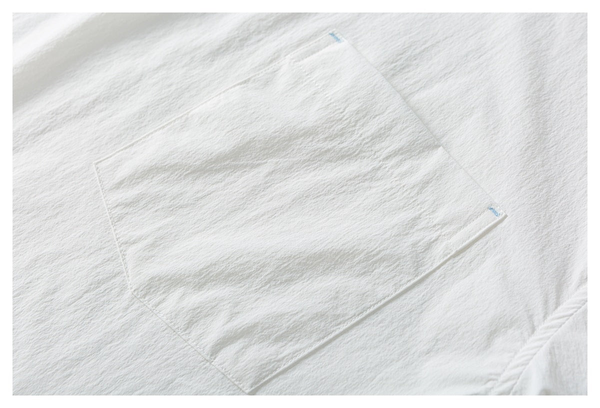 Close-up of a white shirt's stitched rectangular chest pocket.