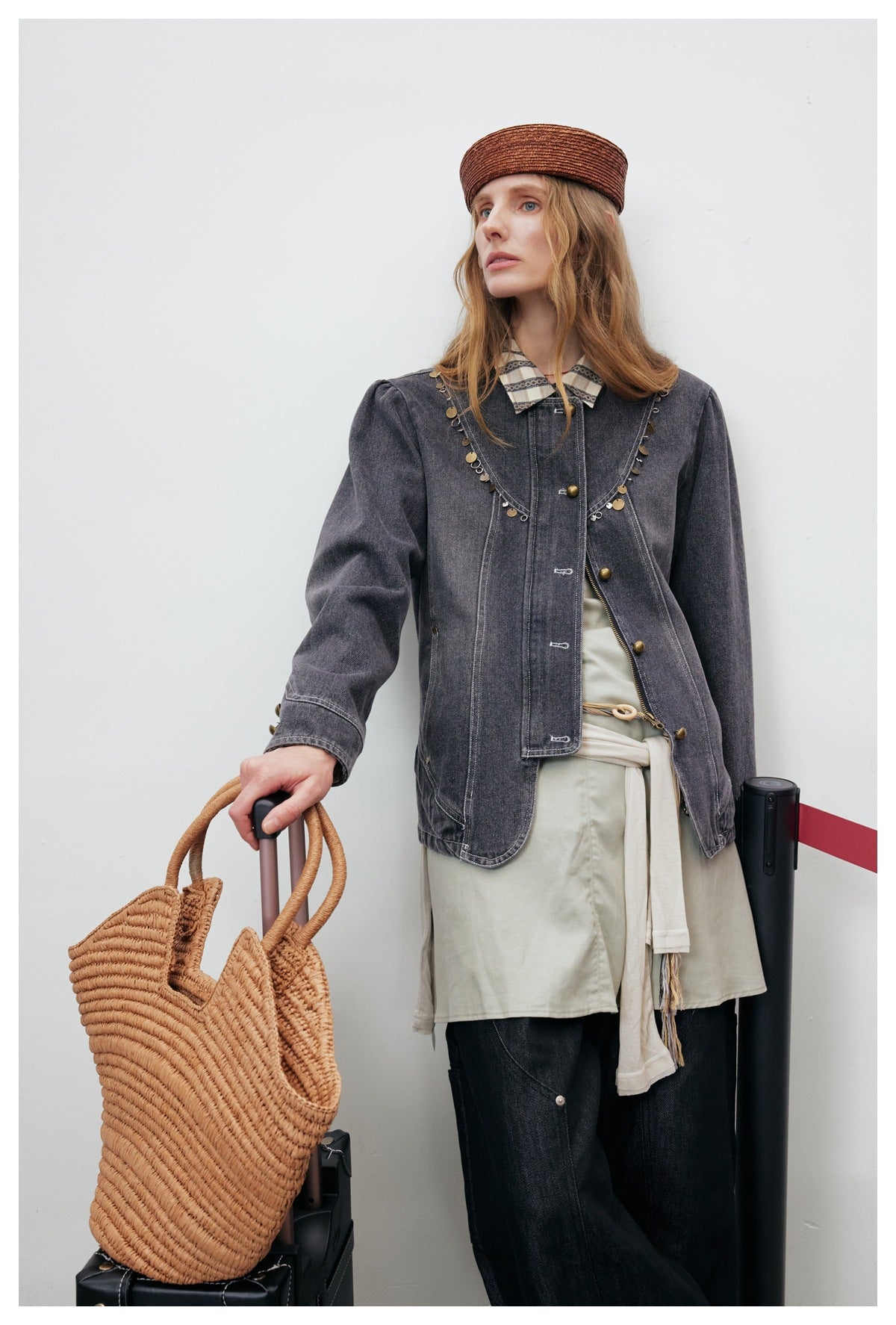 Model wearing a charcoal gray denim jacket with puffed shoulders, curved charm-trimmed seams, and brass-tone buttons.
