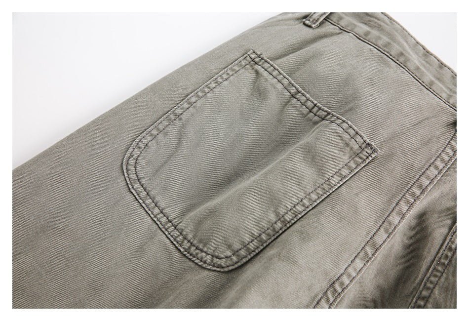 Close-up of a gray-olive trouser back pocket with double-row stitching and surrounding seams.