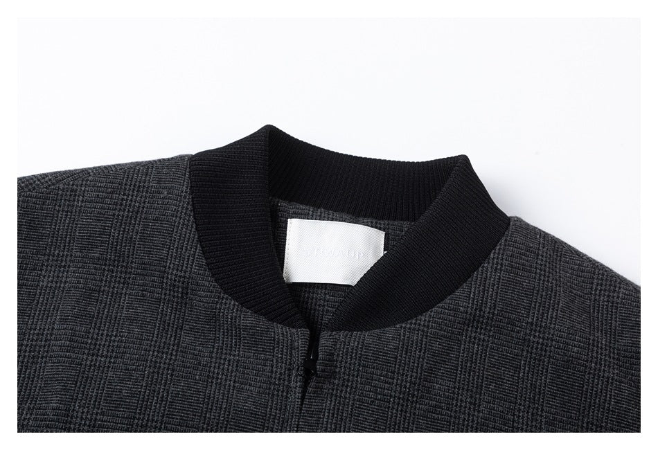 Close-up of the charcoal plaid jacket's black ribbed collar, zipper, and inner neck label.