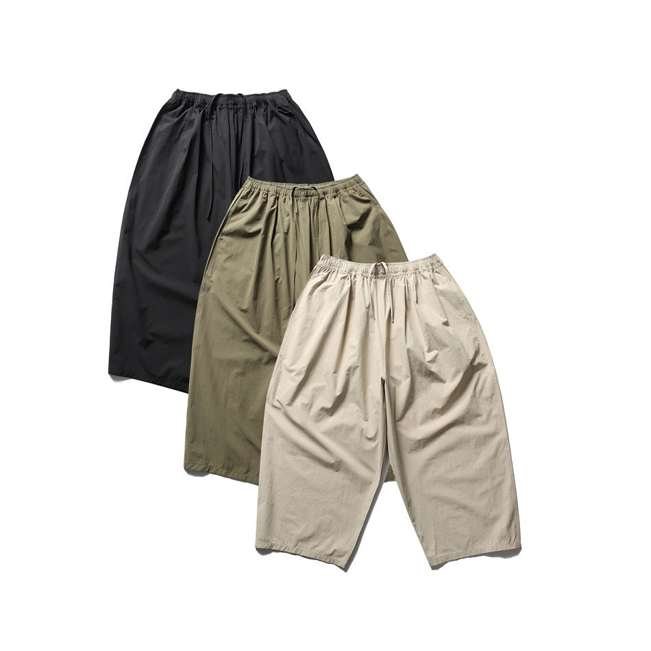 Three pairs of loose cropped pants shown flat in black, olive, and light beige.