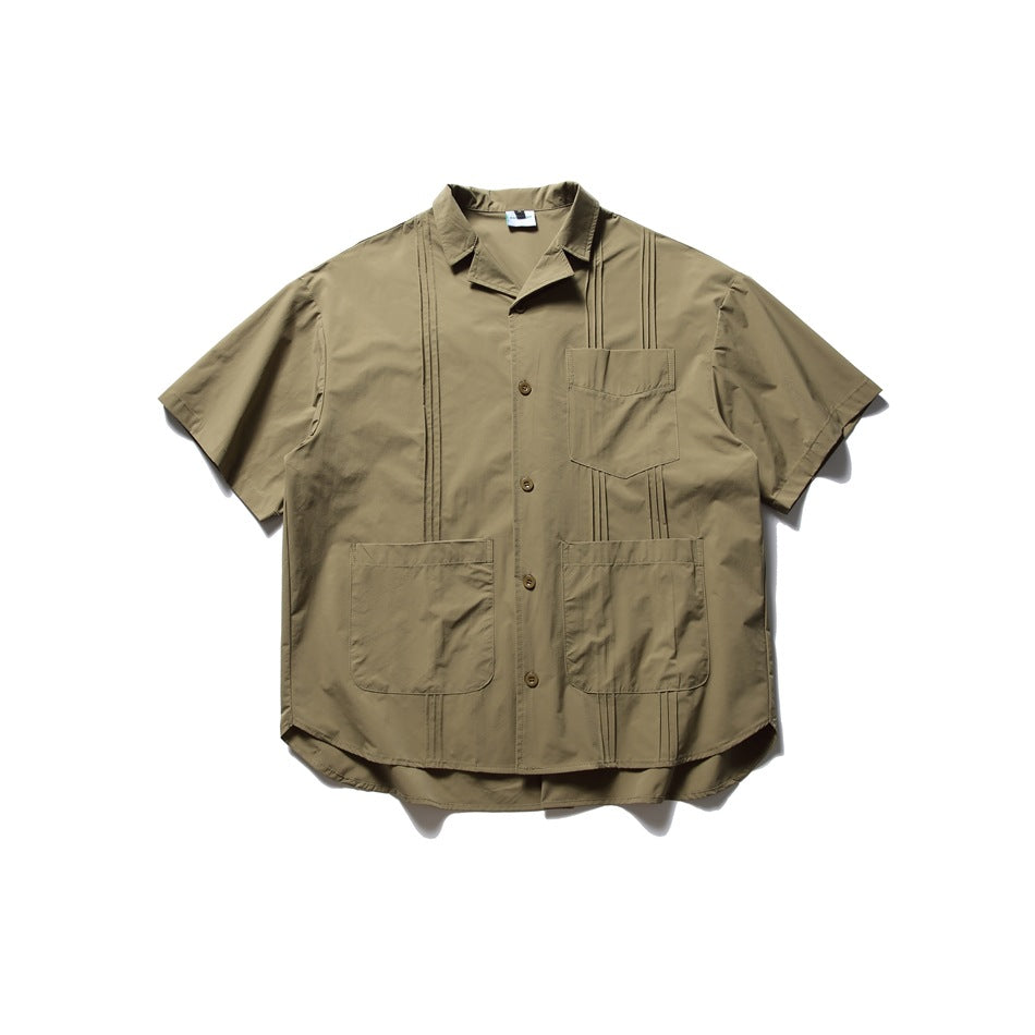 Green short-sleeve button-front shirt with three pockets and pintuck detailing, flat lay