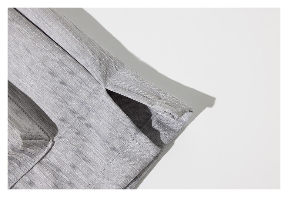 Close-up of the folded edge and stitching of a light gray striped garment.