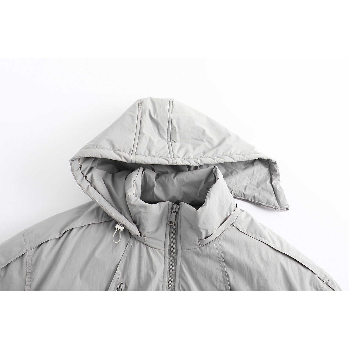 Close-up of a light gray jacket hood, high collar, and front zipper.