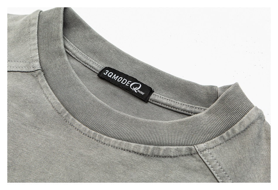 Close-up of the gray shirt’s ribbed crewneck collar, shoulder seams, and black neck label.