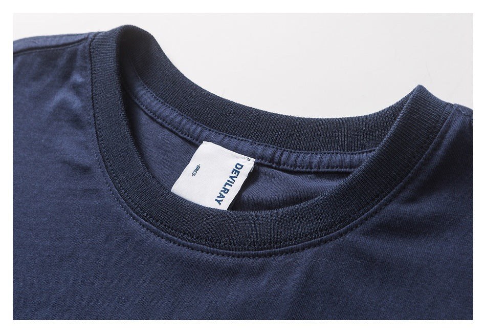 Close-up of a navy T-shirt's ribbed crew neck and sewn-in white DEVILRAY label.