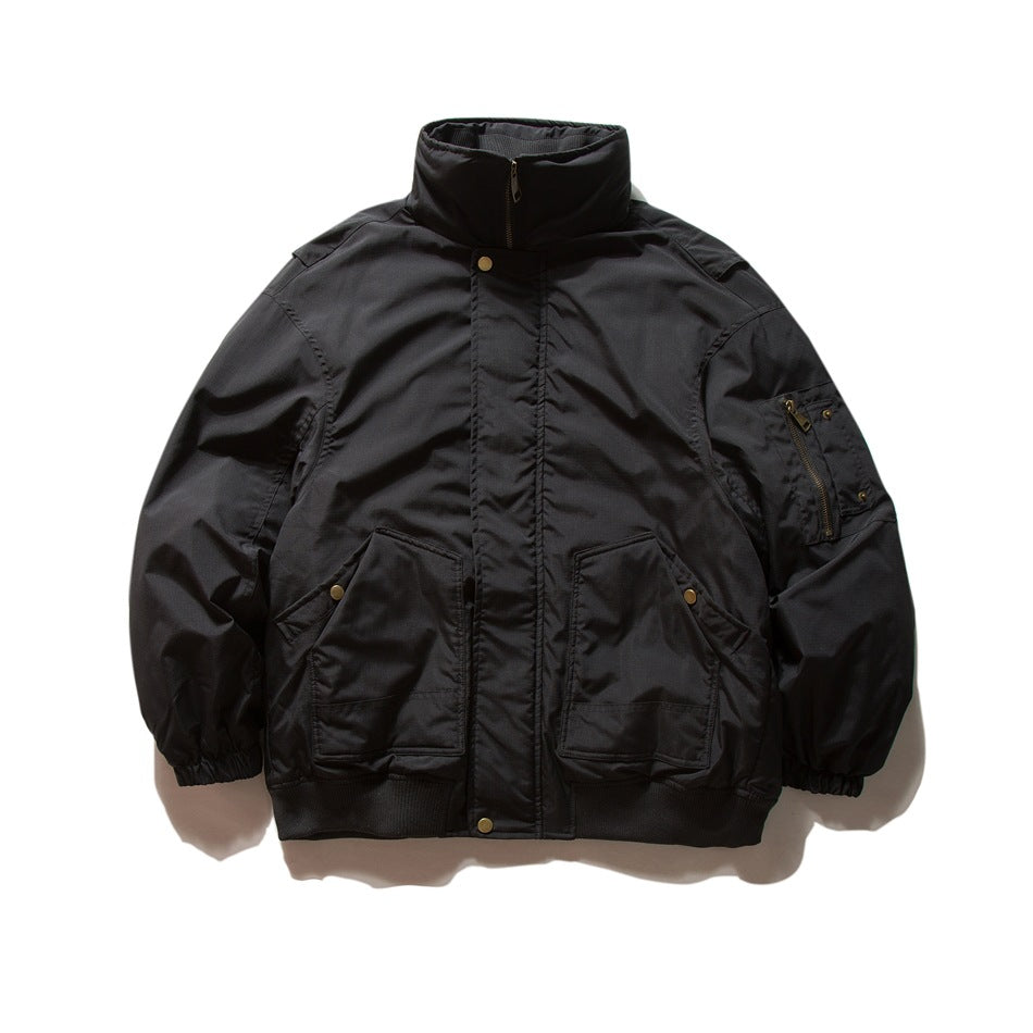 Black stand-collar jacket flat lay with zip front, flap snap pockets, sleeve zip pocket, elastic cuffs and ribbed hem