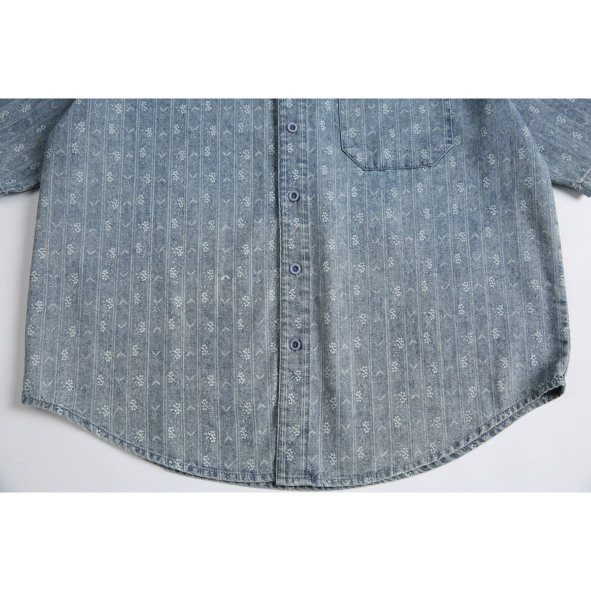 Flat-lay view of a blue-gray short-sleeve button-up shirt with a chest pocket and repeating geometric floral pattern.