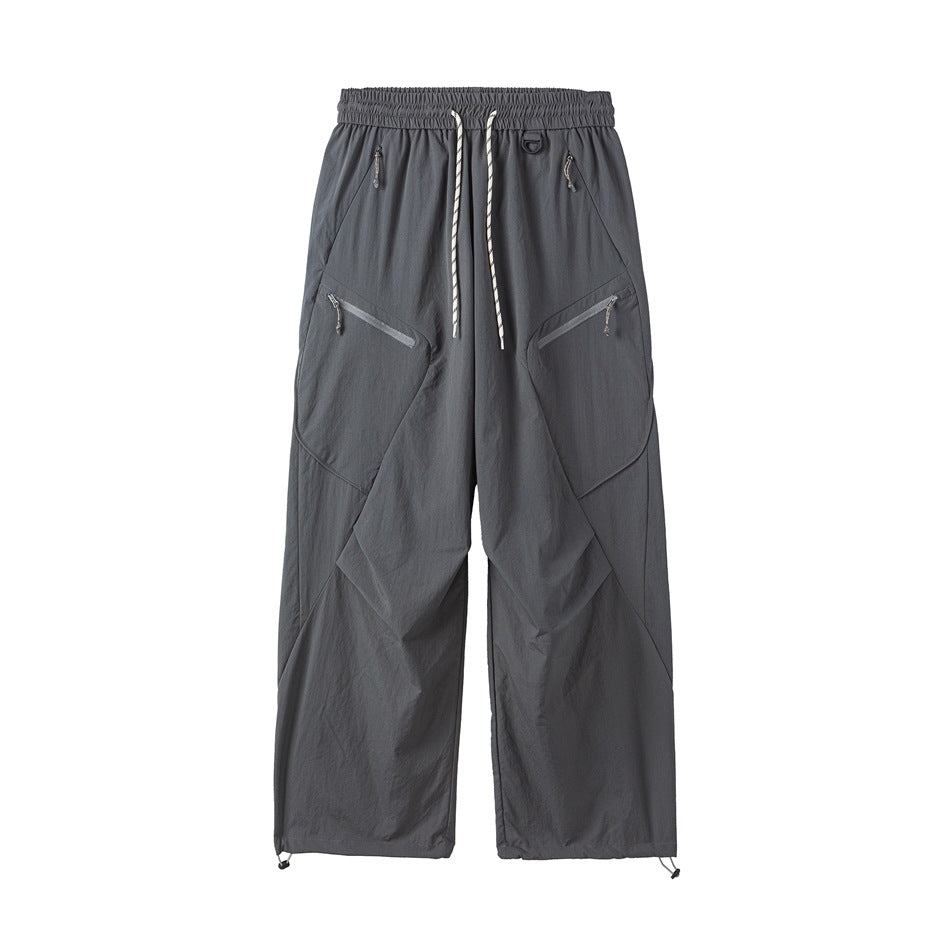 Dark gray wide-leg drawstring pants with diagonal zip pockets and toggle hems, front flat view