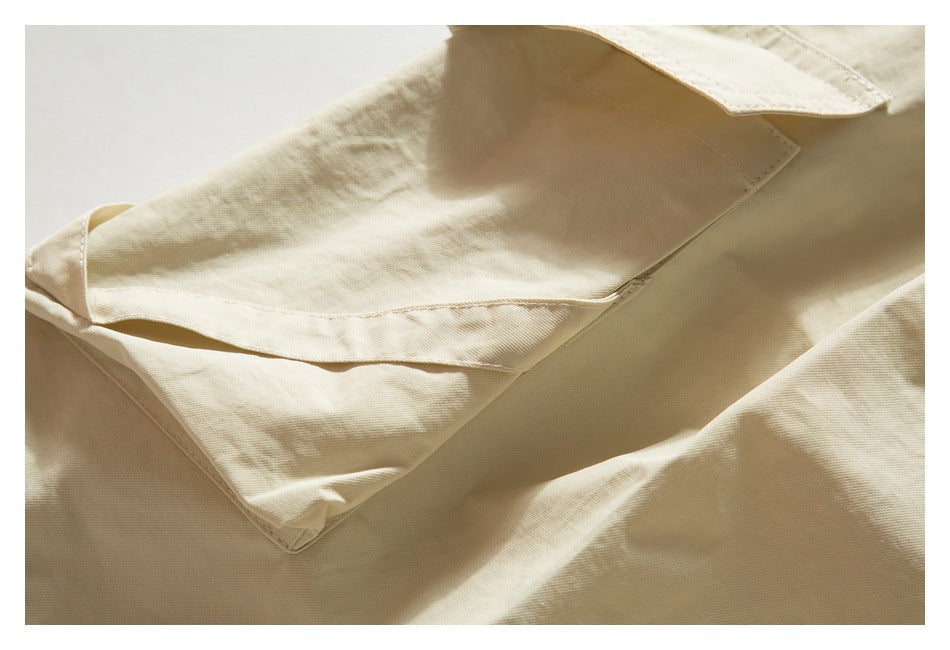 Close-up of a large flap pocket on cream-beige trousers.