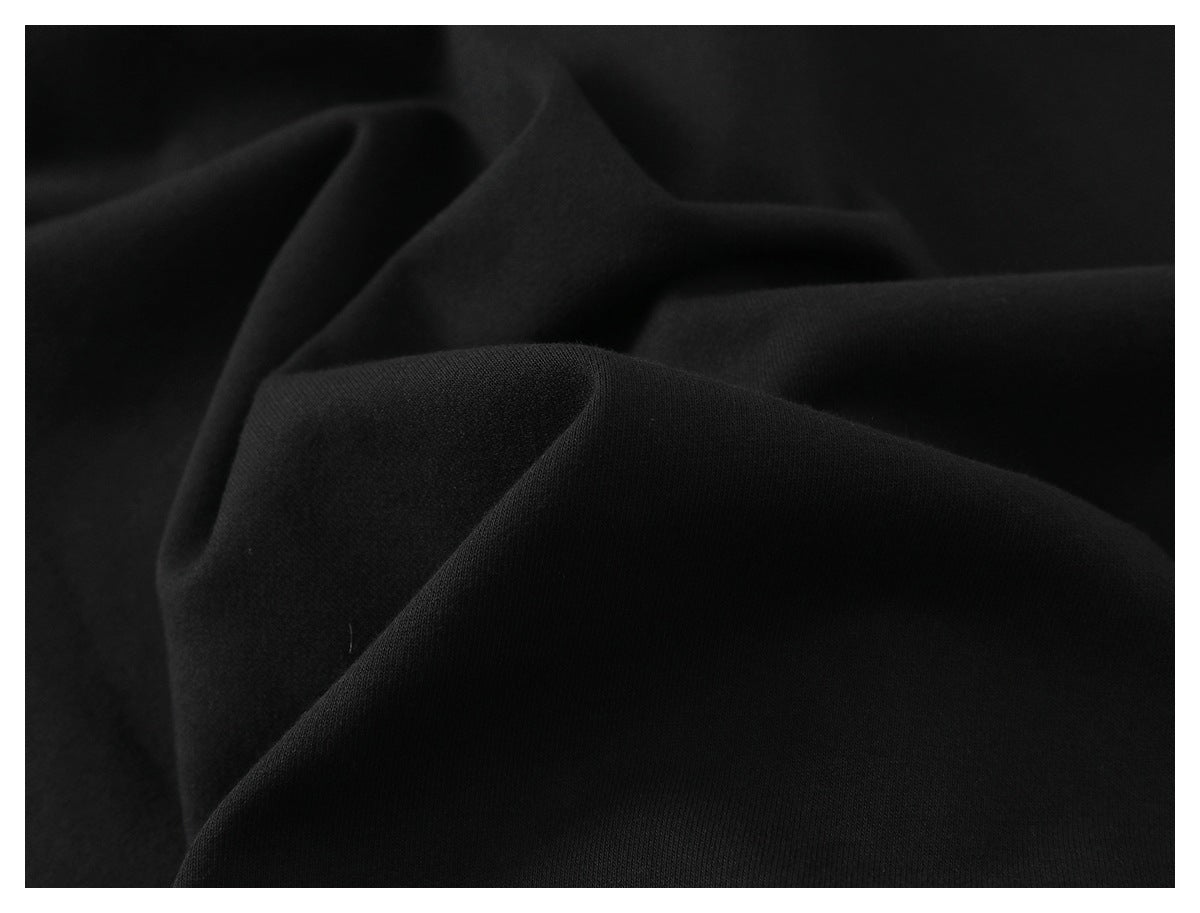 Close-up of softly folded black fabric showing its surface texture.