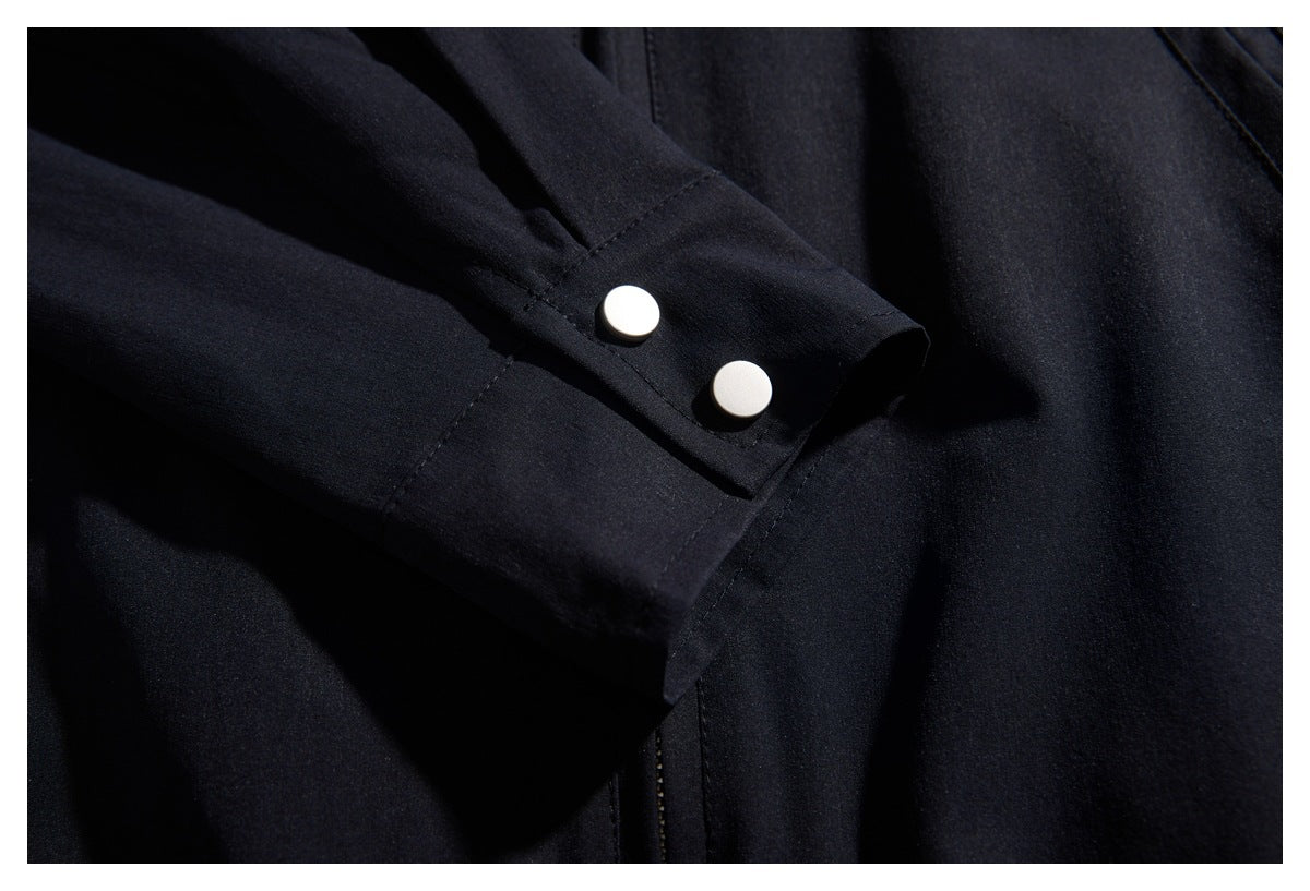 Close-up of a black sleeve cuff with two large white buttons.