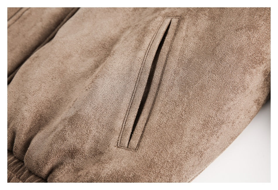 Close-up of a long vertical pocket opening on a brown jacket sleeve.