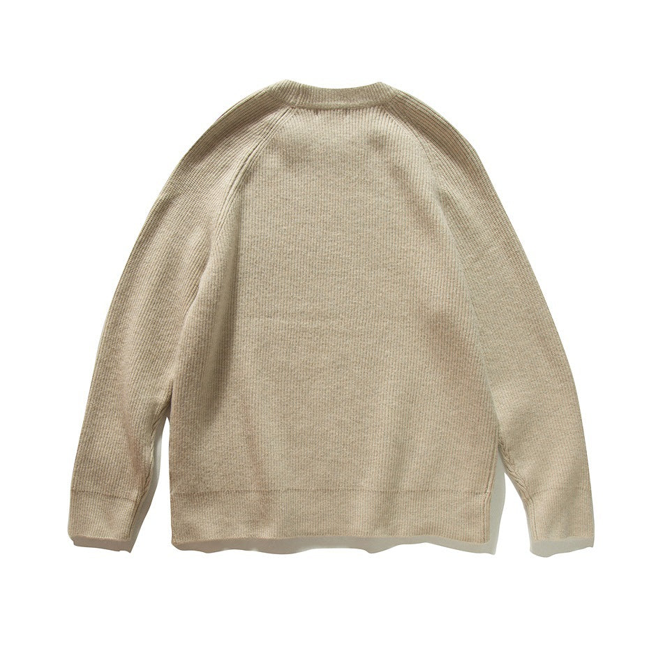 Back view of a plain beige knit sweater with a crew neck, raglan sleeves, and ribbed cuffs and hem.