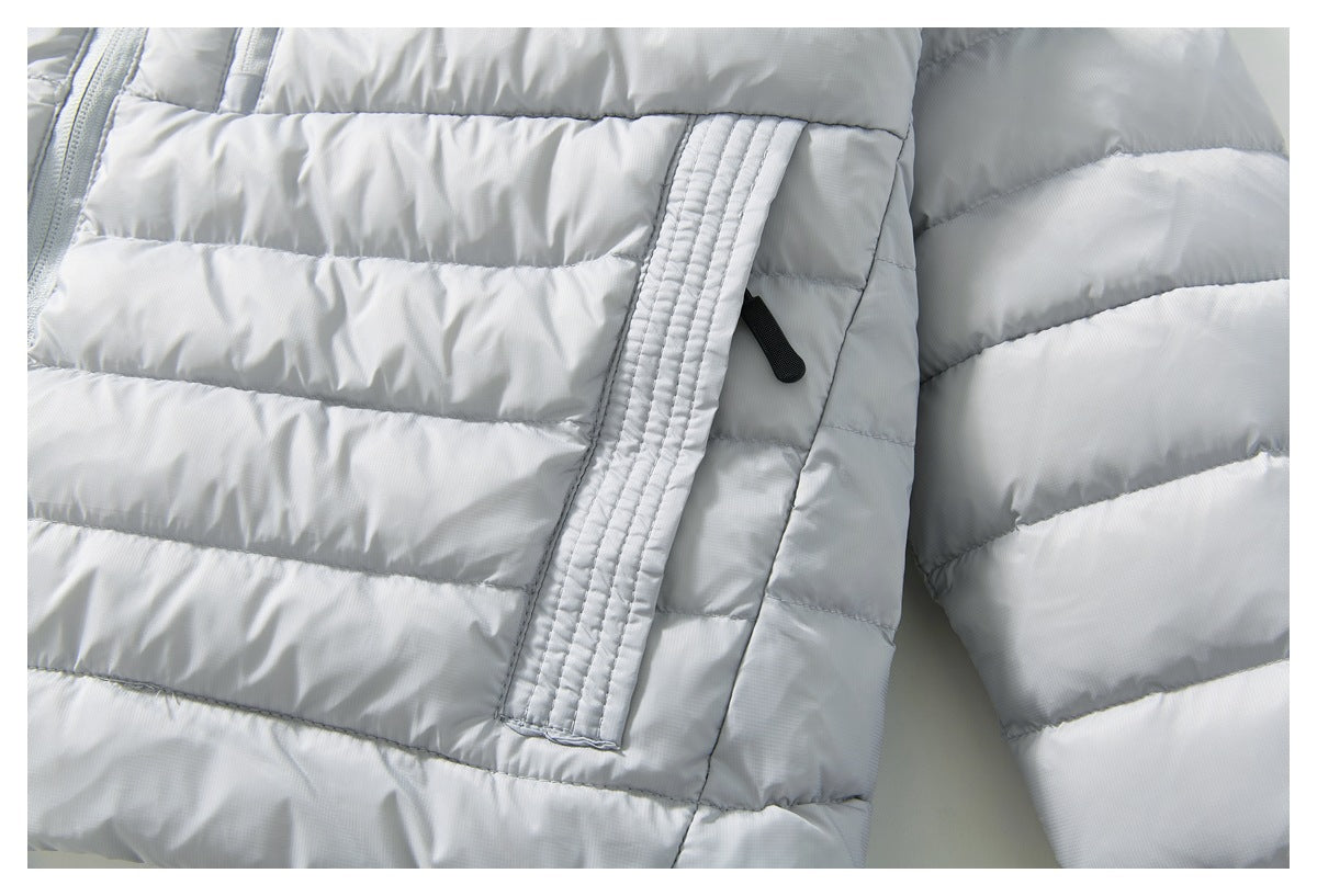 Close-up of a pocket opening and zipper pull on the light gray quilted jacket.