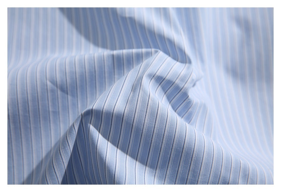 Close-up showing the light blue shirt's narrow striped fabric draped in soft folds.