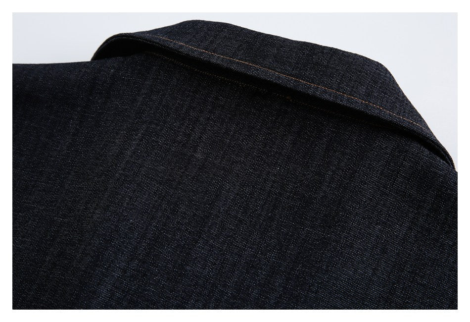 Close-up of a folded dark denim edge with a line of brown stitching.