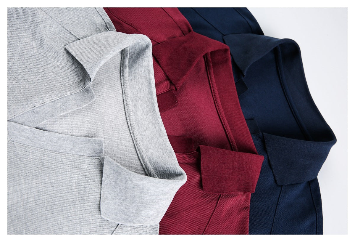 Close-up of overlapping light gray, burgundy, and navy polo shirts, showing their collars and plackets.