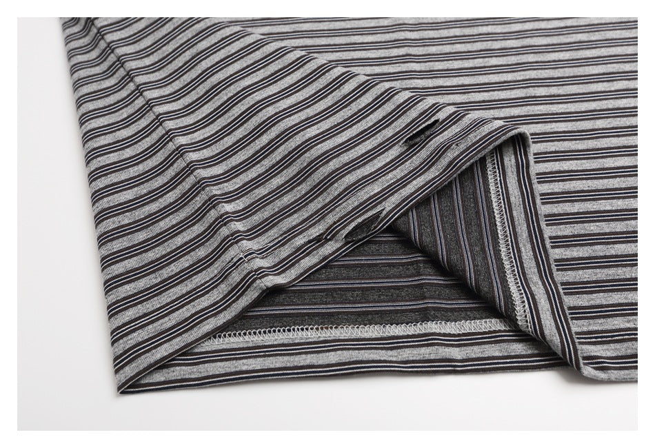 Close-up of the T-shirt's turned-up hem and overlocked seam in gray and black striped fabric.
