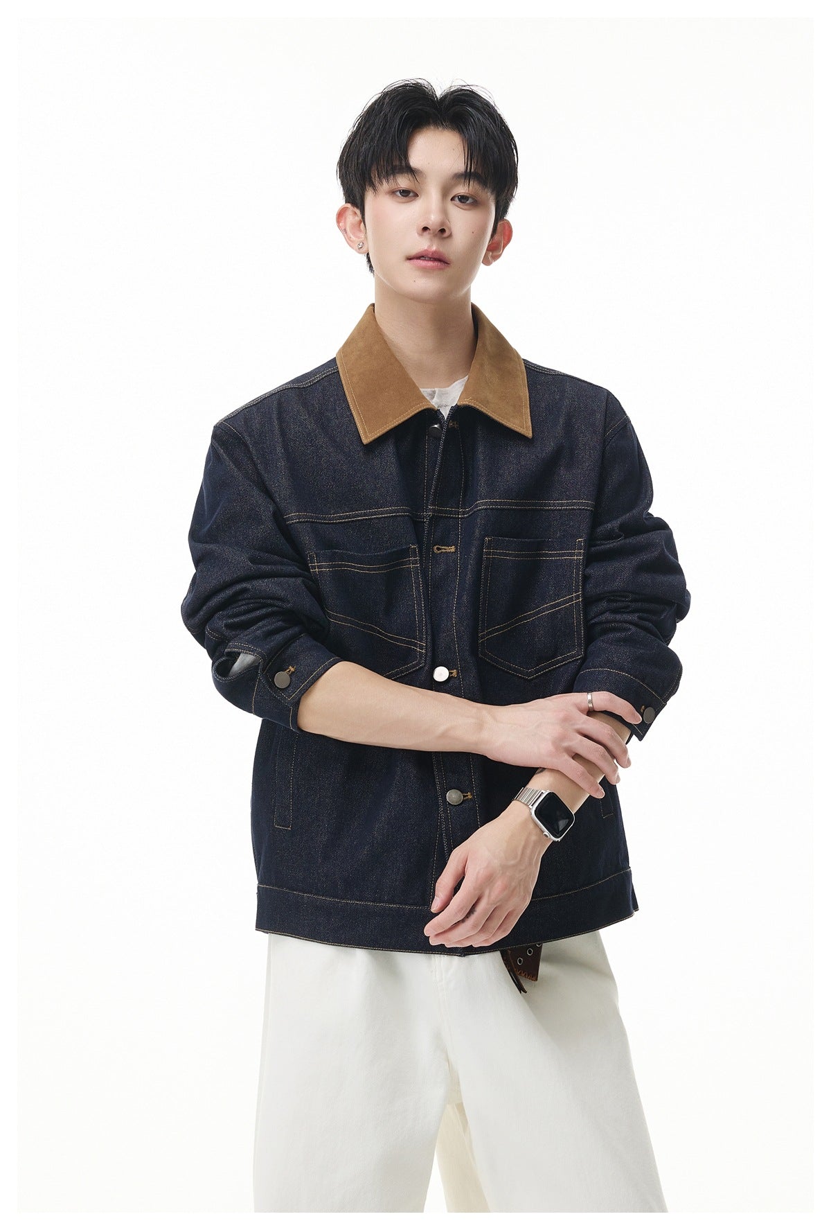 Model wearing a dark indigo denim jacket with a brown collar, button front and two chest pockets.