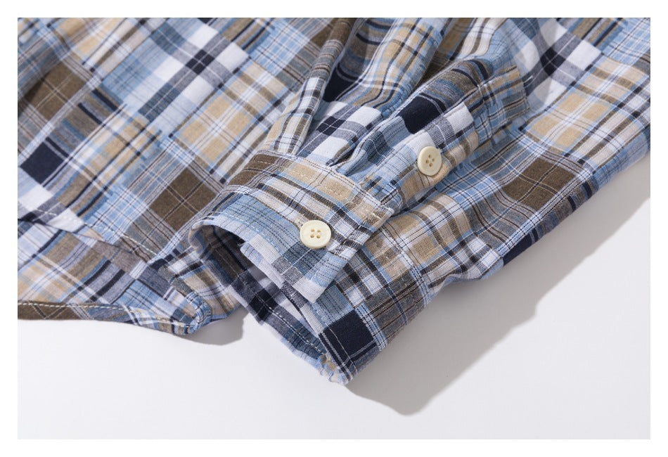 Close-up of the plaid shirt cuff with two cream buttons and a button placket.