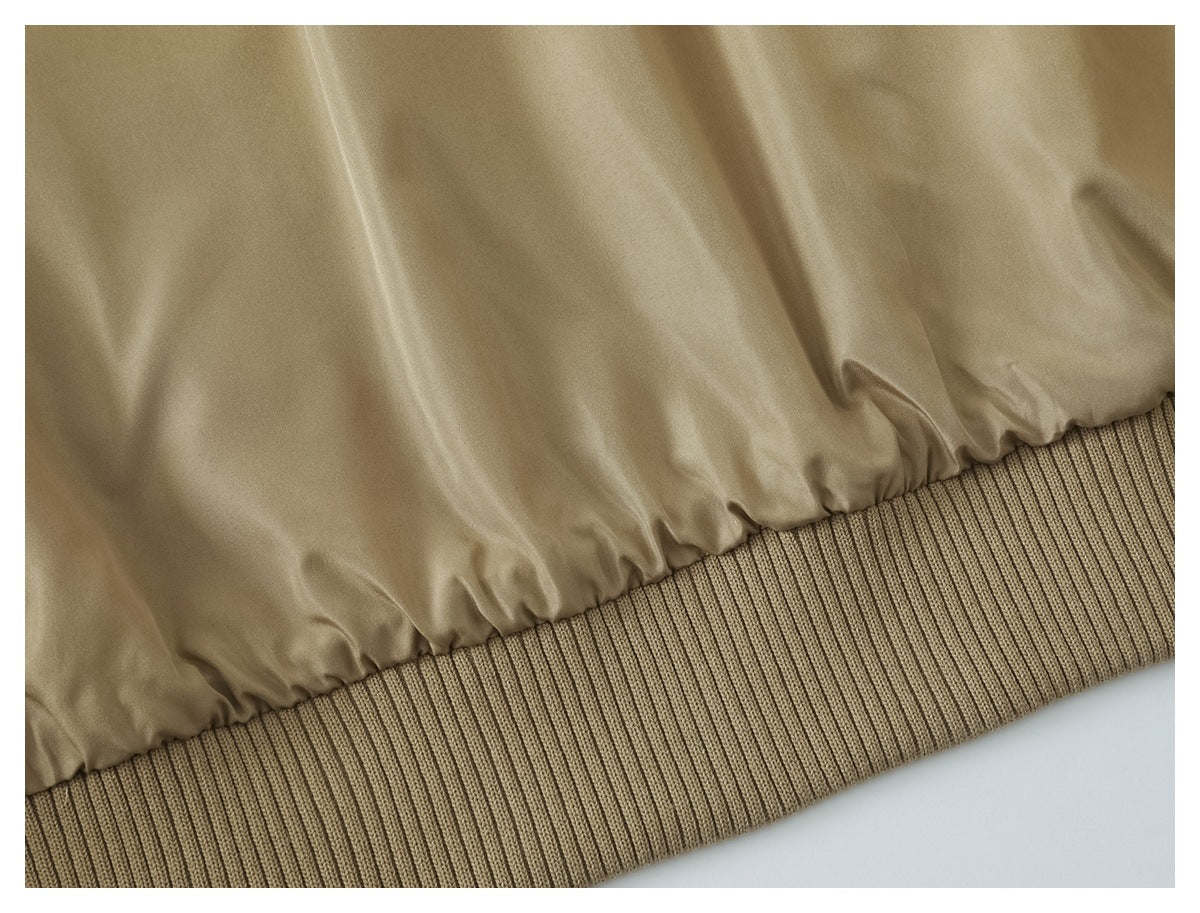 Close-up of a tan garment gathered above a wide ribbed knit hem.