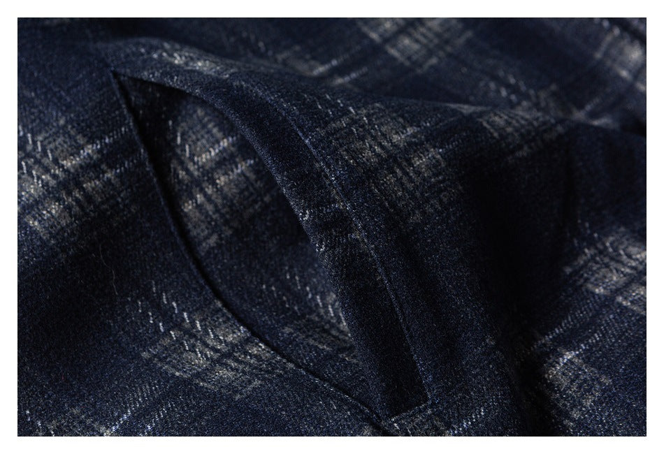 Close-up of a dark navy plaid garment showing a stitched seam and overlapping fabric.