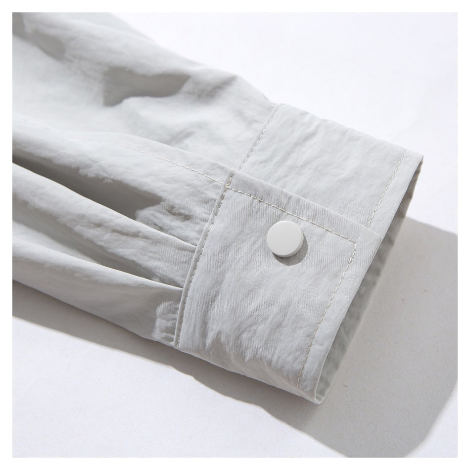 Close-up of a white garment sleeve cuff with visible stitching and a round white button.