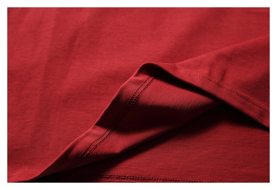 Close-up of red shirt fabric folded back to show the underside and overlocked seam.