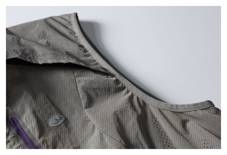 Close-up of the gray vest's armhole binding, shoulder seam, and perforated panel.