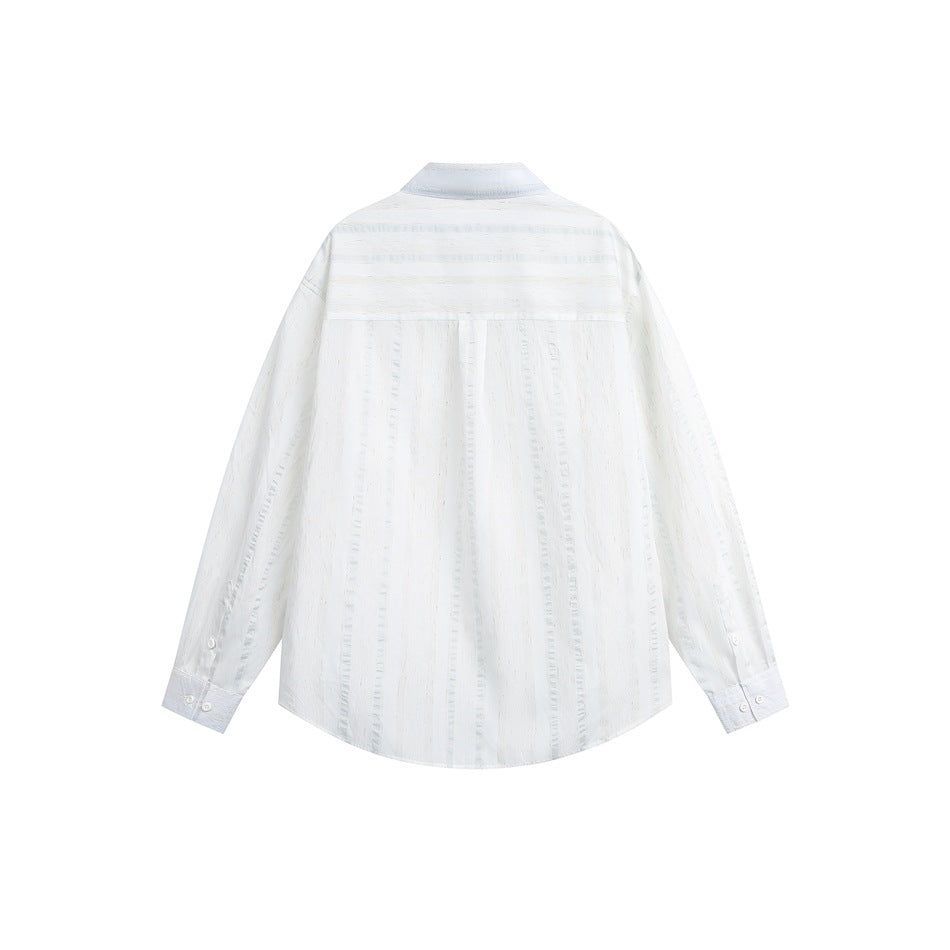 Back view of white textured long-sleeve shirt with horizontal-striped yoke and button cuffs, flat lay