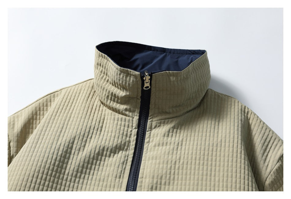 Close-up of a light khaki quilted jacket's high collar, navy lining, and front zipper.