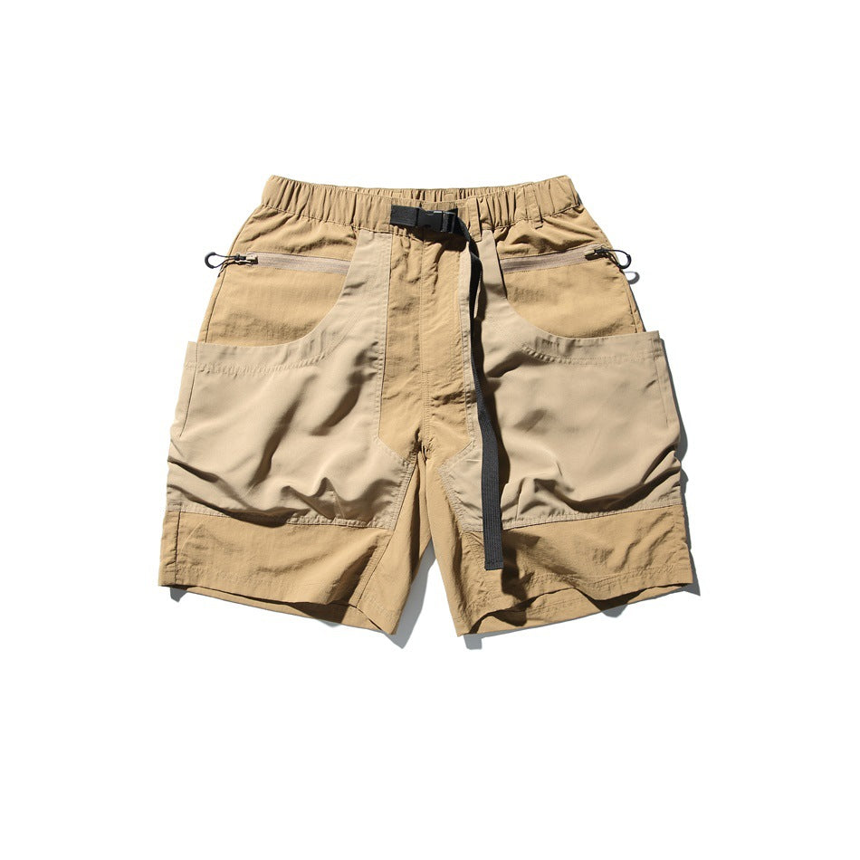 Khaki two-tone utility shorts with elastic waist, black belt buckle, zip pockets and large side patch pockets, flat lay