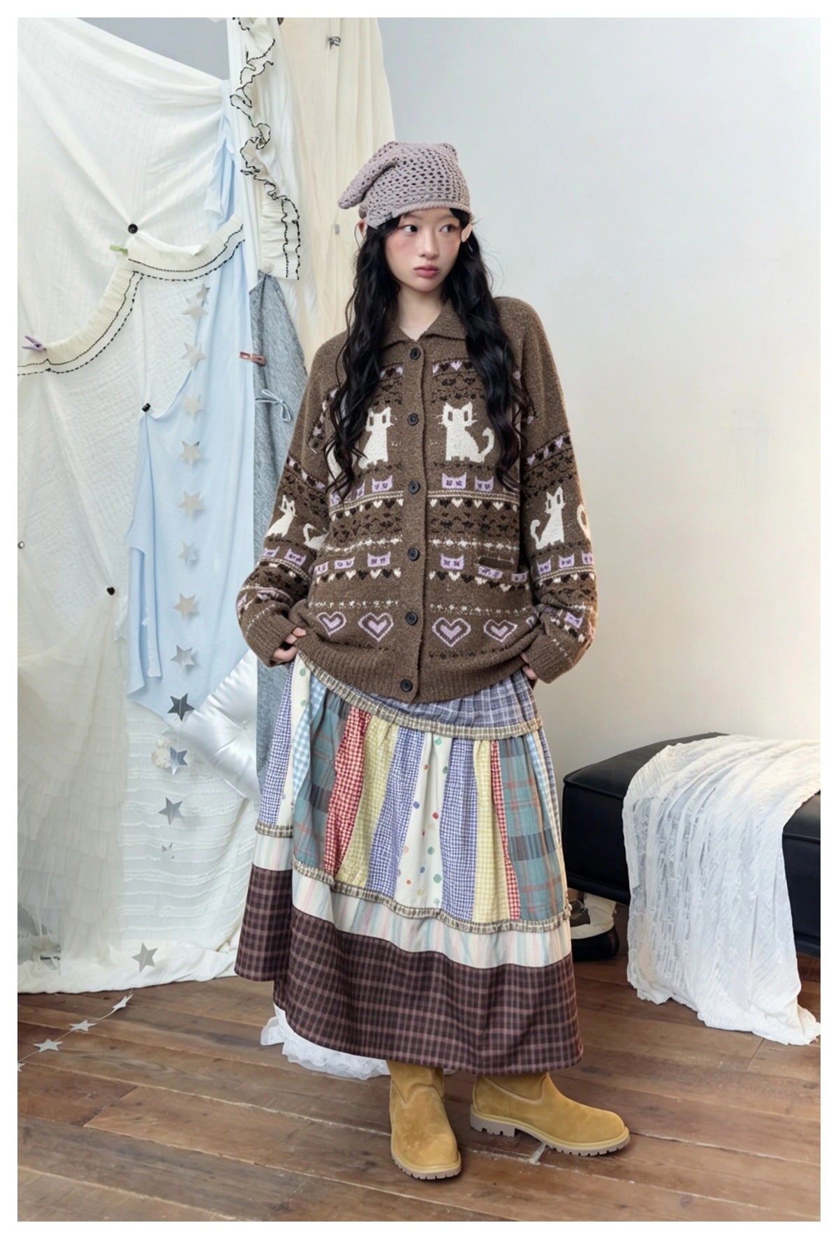 Woman standing in a brown buttoned cat jacquard cardigan with a patchwork plaid skirt and yellow boots