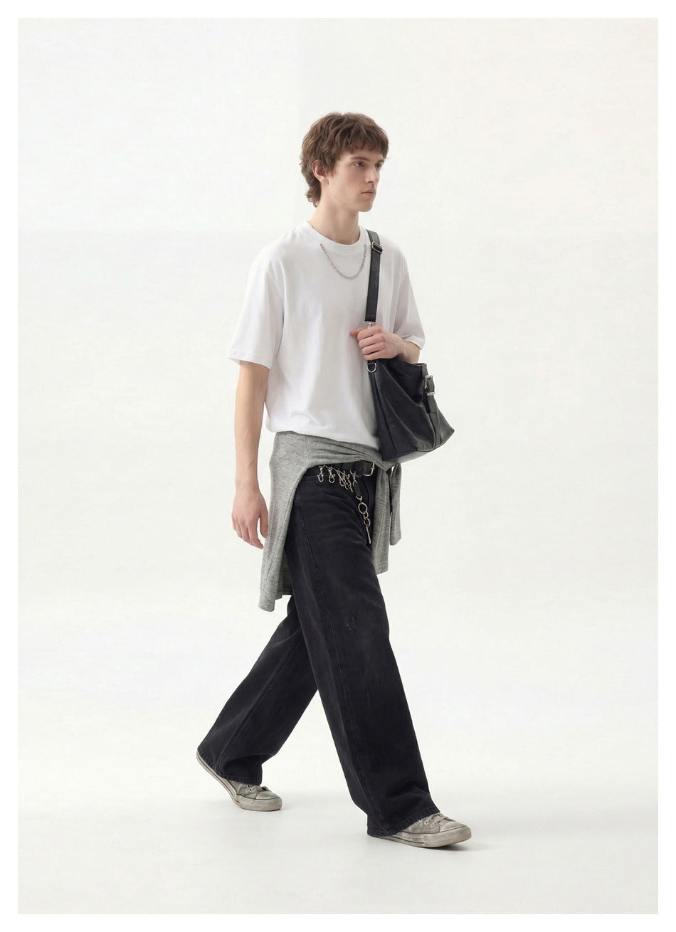 Side view of a model walking in a plain white crew-neck T-shirt and loose black trousers.