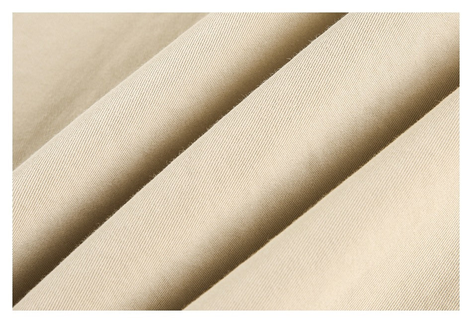 Close-up of beige fabric folded into diagonal ridges, showing a fine ribbed texture.