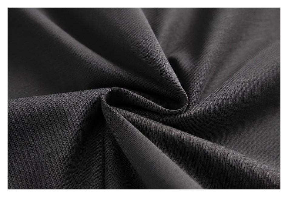 Close-up of charcoal fabric gathered into soft folds, showing its fine surface texture.