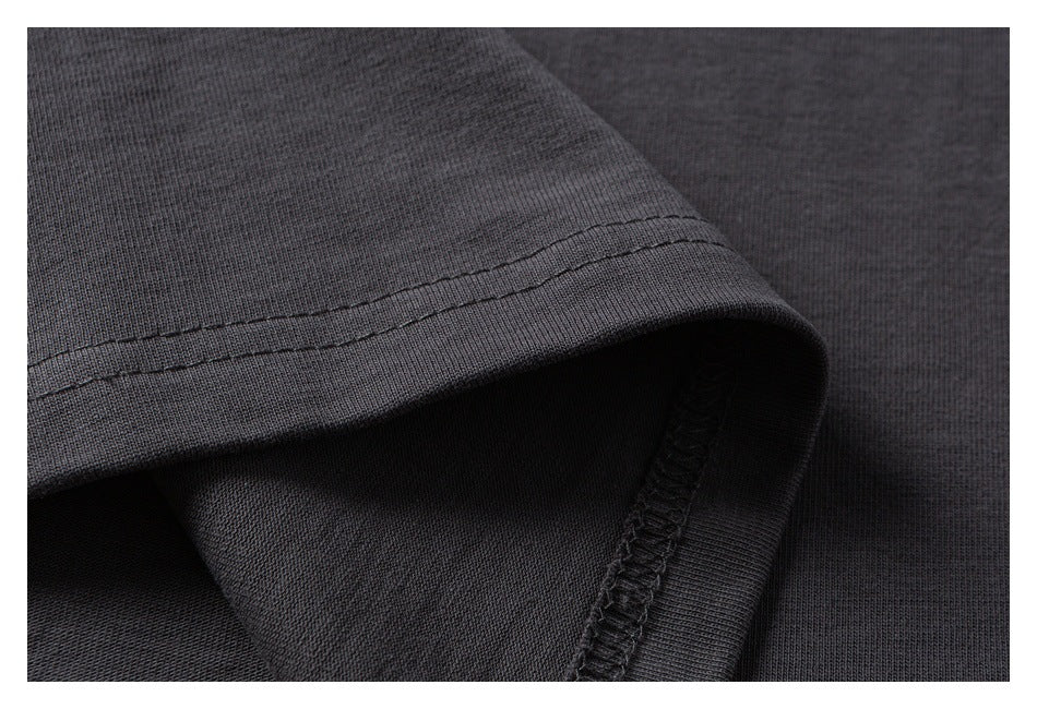 Close-up of a charcoal T-shirt sleeve edge with double stitching and an overlocked inner seam.