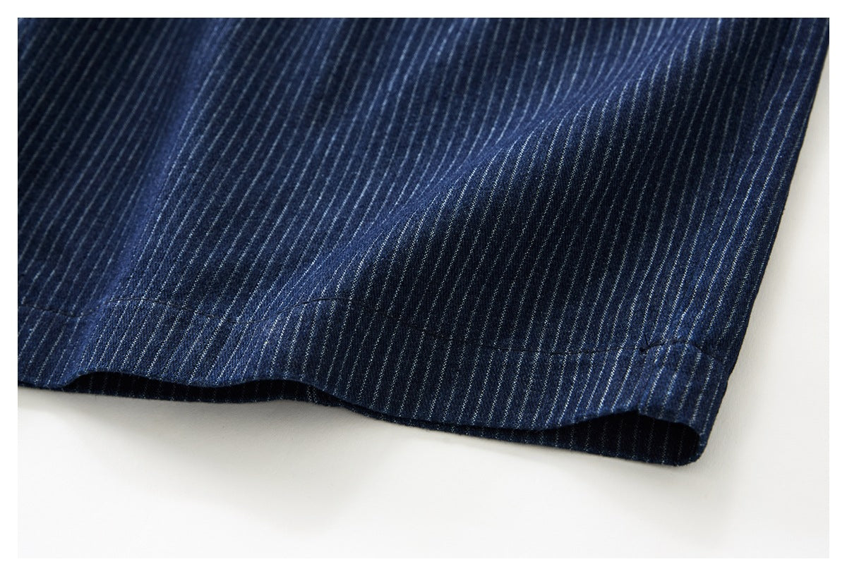 Close-up of the hem of dark navy trousers with narrow light pinstripes.